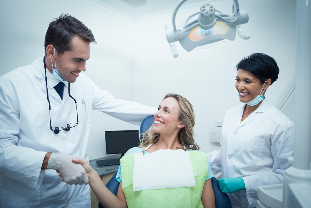 dentistas y pacientre tras empaste dental